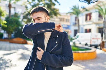 Young hispanic man coughing at park