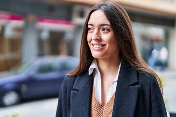 Young beautiful hispanic woman smiling confident looking to the side at street