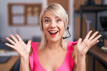 Young caucasian woman wearing call center agent headset celebrating victory with happy smile and...