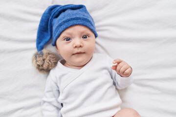 Adorable caucasian baby lying on bed at bedroom