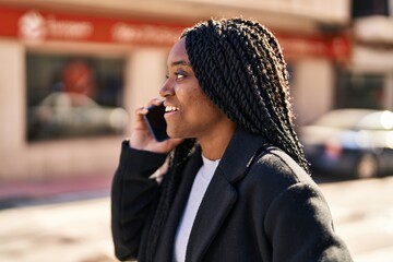 African american woman smiling confident talking on the smartphone at street