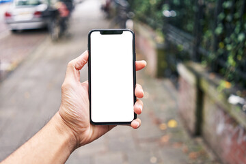 Man holding smartphone showing white blank screen at street