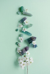 Crystal towers minerals set and white flowers on green abstract background. gemstones for Healing...