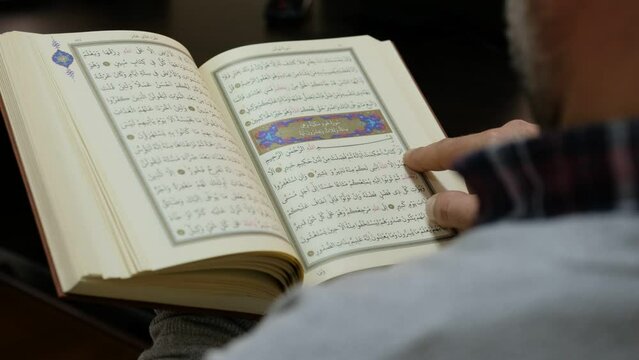 A man reading an Antique Book written in Arabic