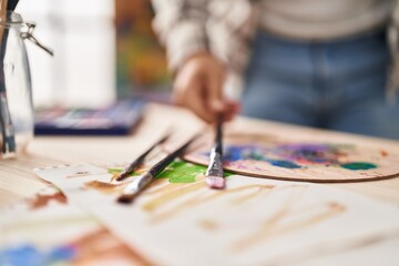 Obraz premium Young hispanic man holding paintbrush at art studio