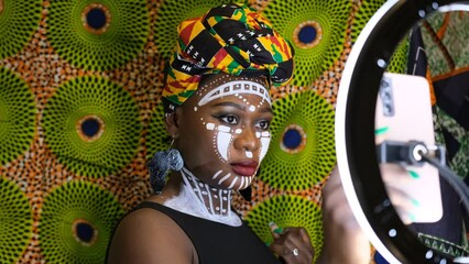 African woman with traditional face painting from Ghana connects to social media.