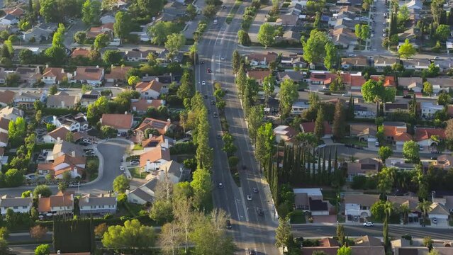 Aerial drone shot of residential Los Angeles suburban housing district area in USA. American homes in quiet neighborhood at golden hour. Beautiful green suburb aerial at scenic sunset 4K California