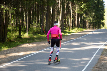 Roller skis.A woman runs in a summer park on roller skis.Cross country skilling.
