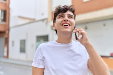 Non binary man smiling confident talking on smartphone at street