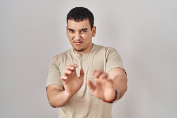 Young arab man wearing casual t shirt disgusted expression, displeased and fearful doing disgust face because aversion reaction.