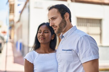 Man and woman interracial couple standing together at street