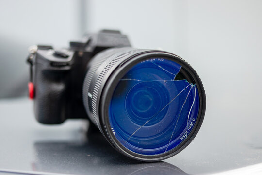 DSLR camera with broken protective glass for lens. Cracked photo-filter