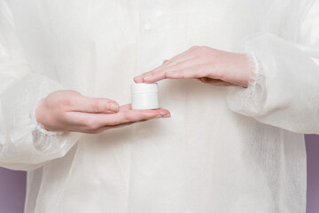 Hand of doctor holding jar of ointment, pills, tablets. Medicine bottle mockup