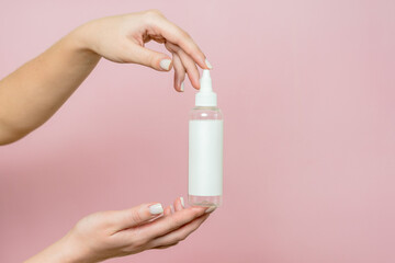Cosmetic bottle in woman's hands. Cosmetic product branding mockup. Spa beauty treatment concept