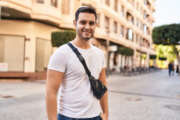 Young hispanic man smiling confident standing at street