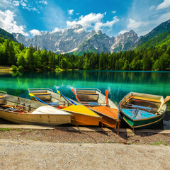 Colorful tourist rowing boats anchored on the lake Fusine, Italy