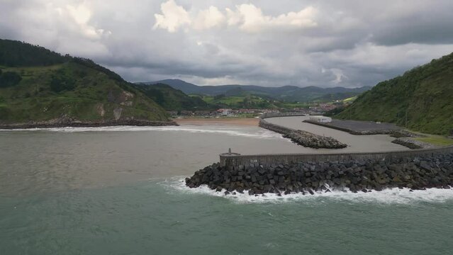 Orio breakwater. Beach and town in the background. Gipuzkoa, Cantabrian Sea