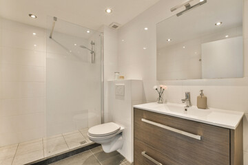 a bathroom with a toilet, sink and shower stall in the photo is taken from the front end of the room