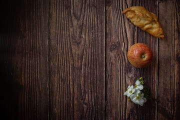 Fototapeta na wymiar Little pastries with apples on dark wooden background 