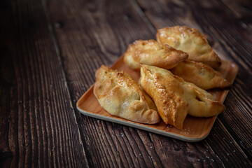 Little pastries with apples on dark wooden background 