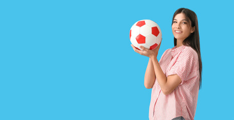 Young woman with soccer ball on blue background with space for text