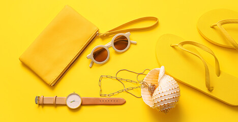 Stylish bag with seashell and different accessories on yellow background
