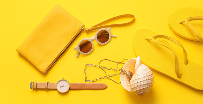 Stylish bag with seashell and different accessories on yellow background