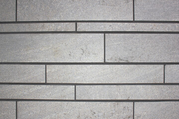 Facade of a building made of blocks of gray color, texture, background close-up. Blocks, stone structure of seams and blocks design.