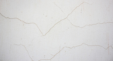 Cracks on a white wall.Cracked plaster background,authentic texture.