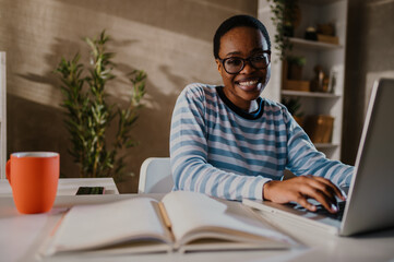 Smiling african american woman a laptop while working in a home office