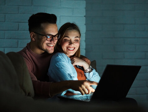 television watching couple laptop night computer young home evening woman man movie entertainment sofa fun happy
