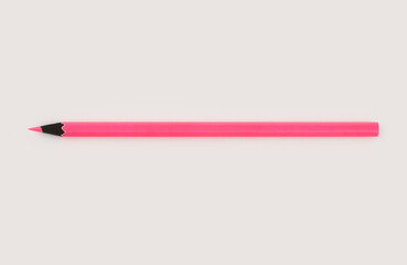 Neon pink color pencil on light beige neutral background..
