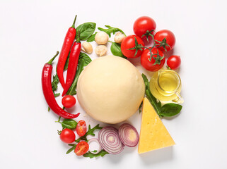 Raw dough and ingredients for preparing pizza on white background