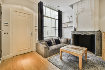 a living room with couches and a fire place in the middle of the room on the right is a fireplace