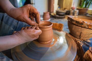 ceramics, workshop, ceramic art concept - close-up of man's hands forming a new vessel, man's...