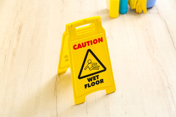 Fototapeta na wymiar Caution sign on wet floor in room, closeup