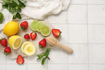 Juicer and ingredients for preparing strawberry lemonade on white tile background