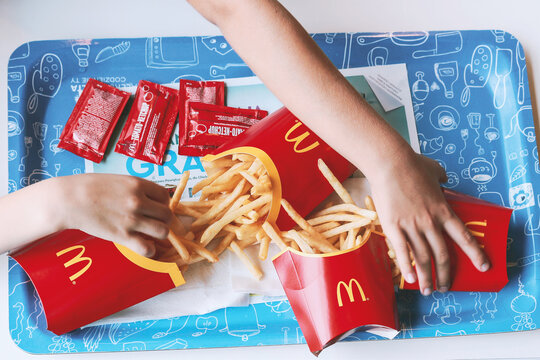 Poznan, Poland - July 18, 2018. Children reaching for chips in a McDonald's restaurant