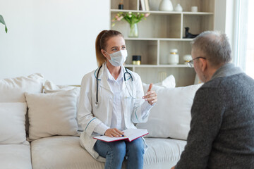 Obraz premium Female doctor examining older senior man in doctor office or at home. Old man patient and doctor have consultation in hospital room. Medicine healthcare medical checkup. Visit to doctor