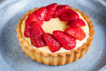 Strawberry tart, popular French pastry or Italian. Served on a plate placed on a rustic wooden table. Seasonal dessert. 