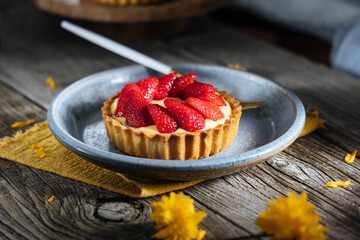 Strawberry tart, popular French pastry or Italian. Served on a plate placed on a rustic wooden table. Seasonal dessert. 