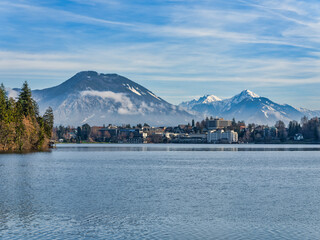 Lakeside town buildings and snow peak mountains during a winter afternoon, Bled, Slovenia