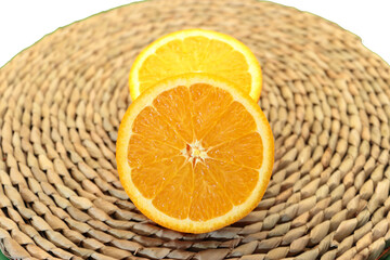 라탄접시 위에 상큼하고 달콤하게 잘익은 오렌지의 단면
