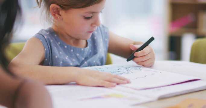 Kids, girl and drawing with pencil in classroom learning art, education or students development of creative process. Young child, hands writing or working on paper in kindergarten with pen marker