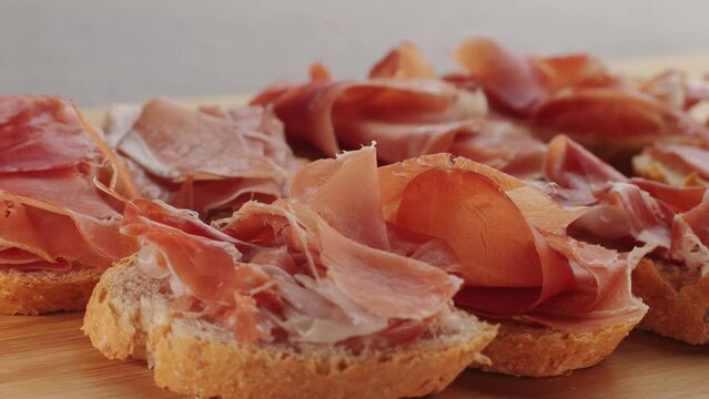 Jamon iberico tapas close up, chef cooking the best spanish ham pork tapas, cafe with traditional food.