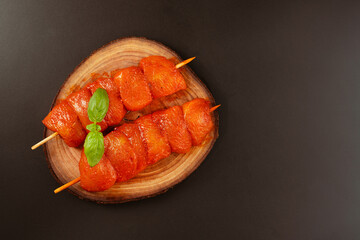 Fresh raw marinated chicken fillet skewers with fresh herbs on a black background..Food concept.Closeup of chicken meat.Procurement for designers.Chicken breast FilletsTop view.