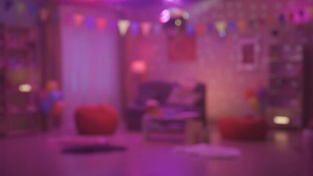 Blurred colorful glow reflecting from a mirrored disco ball inside the room. Defocused interior of a room decorated for a home party or birthday. HDR BT2020 HLG Material.