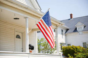 US flag proudly displayed in front of an American house symbolizes patriotism, national identity,...