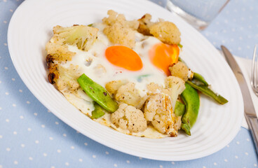 Appetizing breakfast - scrambled eggs with cauliflower and green beans