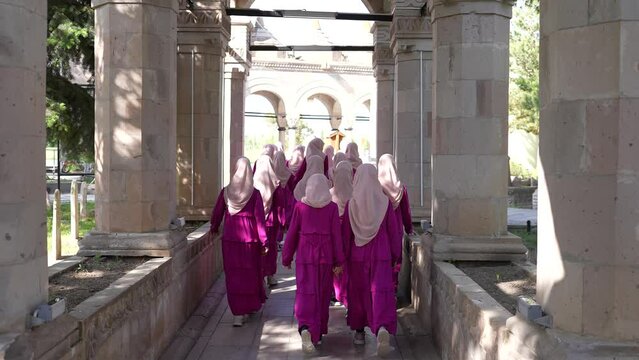 Girl students wearing Hijab walking towards school together